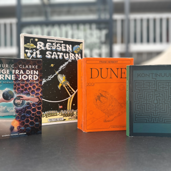 Fire science-fiction bøger på et bord i biblioteksrummet