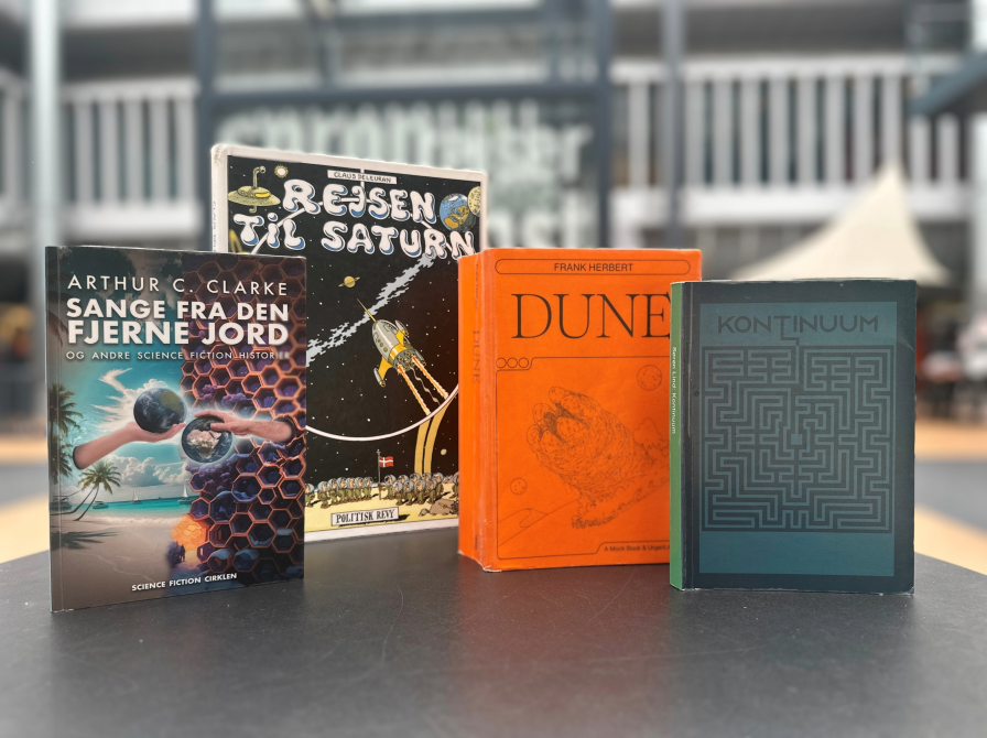 Fire science-fiction bøger på et bord i biblioteksrummet
